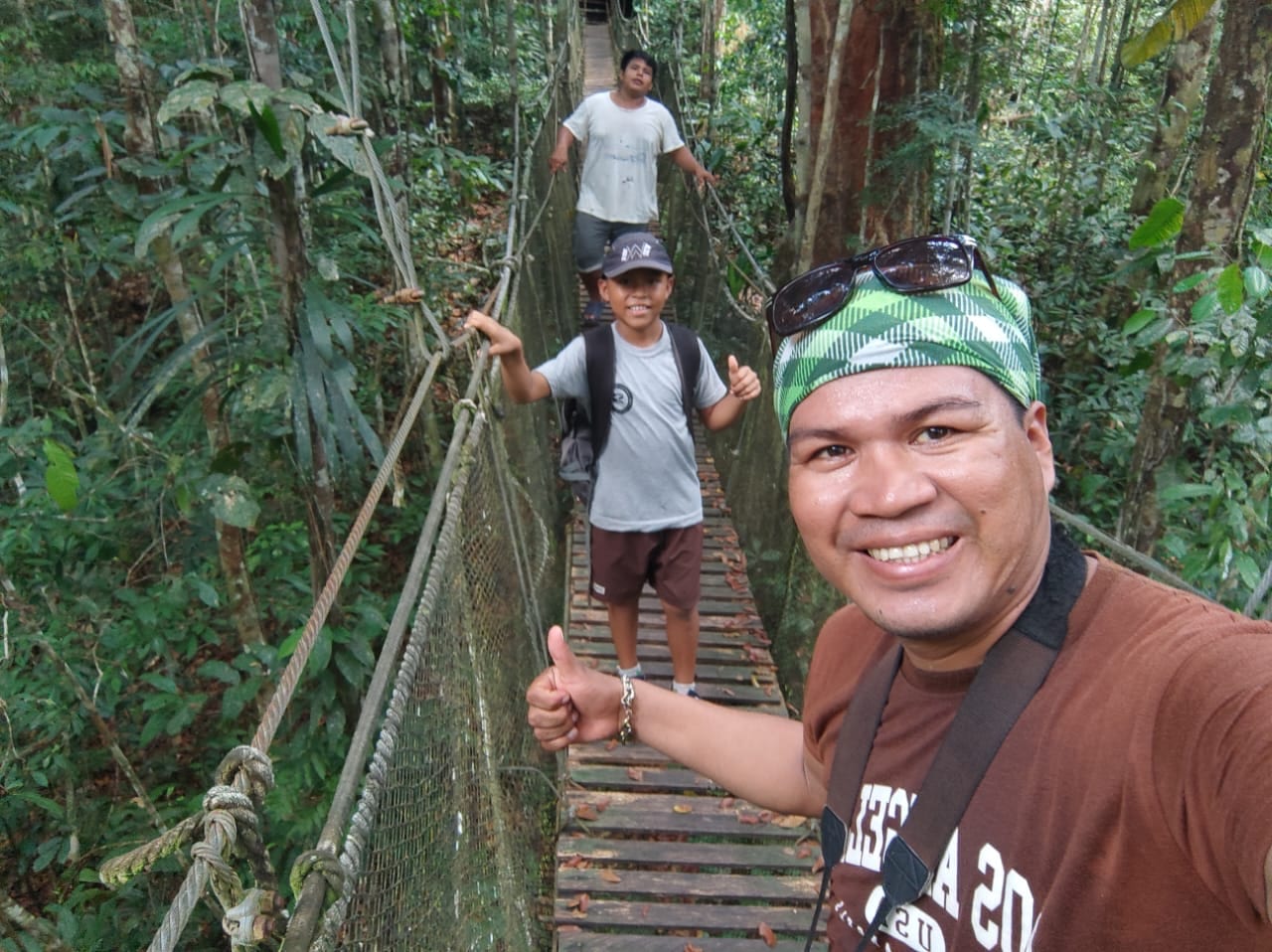 Guests crossing a jungle canopy suspension bridge near San Regis, Peruvian Amazon