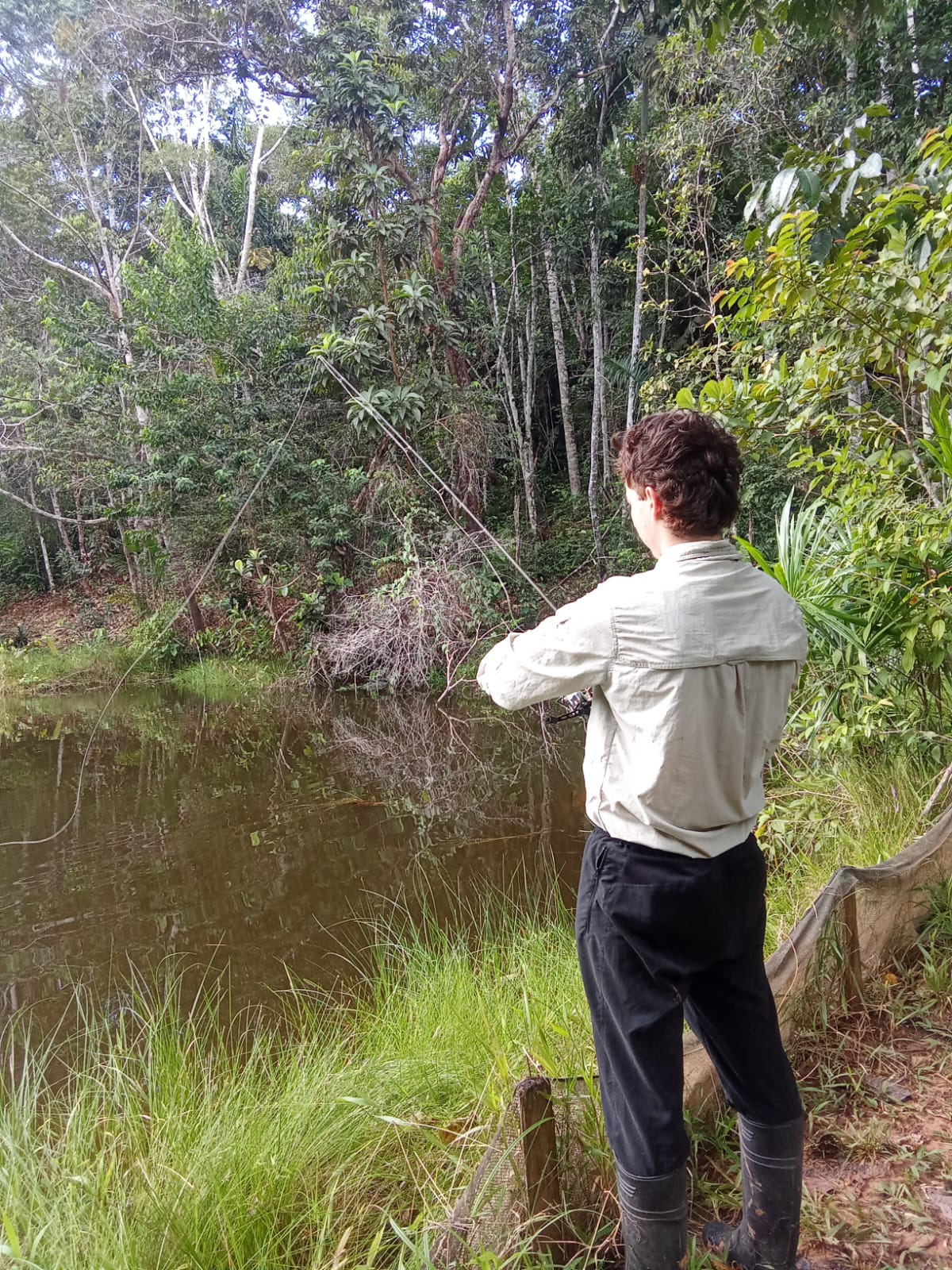 Angler casting into a jungle pond near San Regis in the Peruvian Amazon