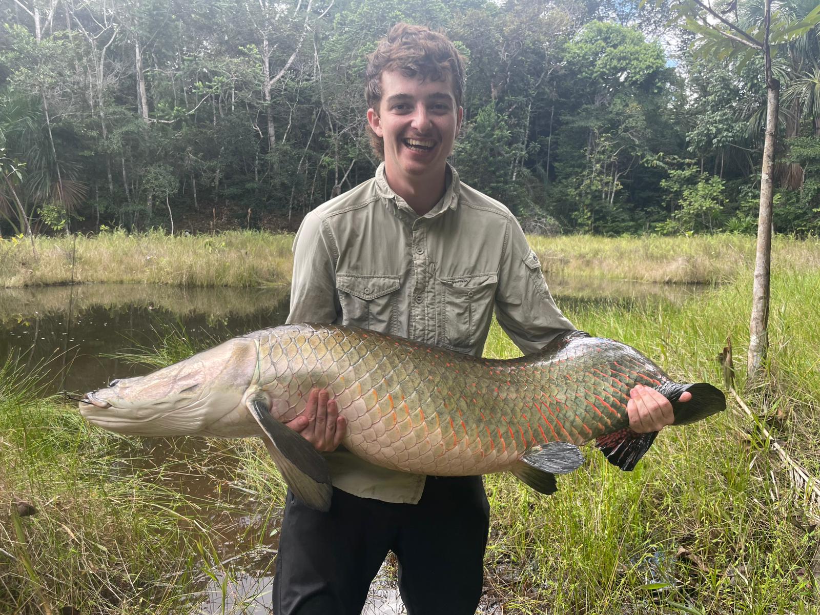 Angler holding a giant paiche (arapaima) caught in the Peruvian Amazon