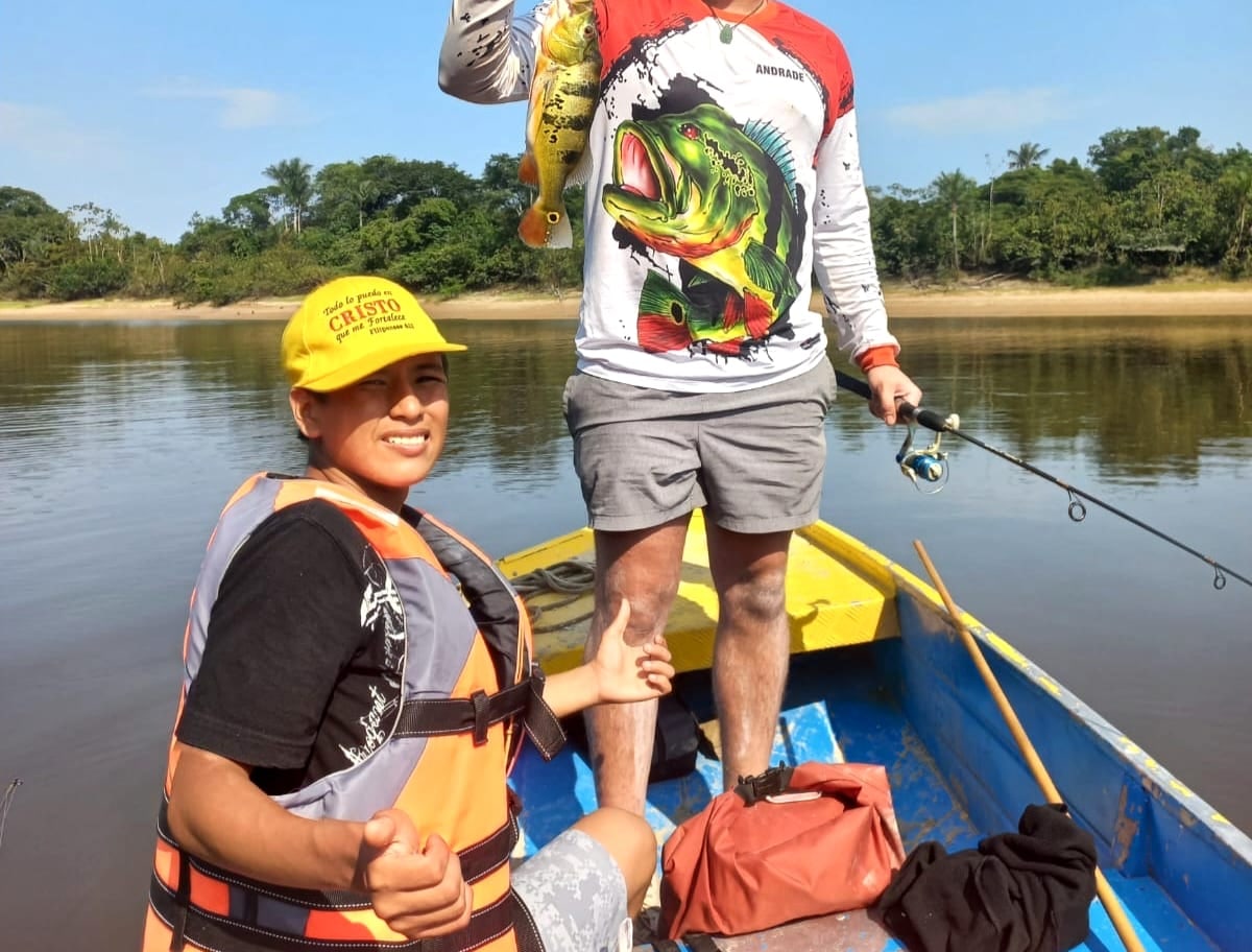 Anglers in a boat with a peacock bass caught on the Nanay River near Iquitos
