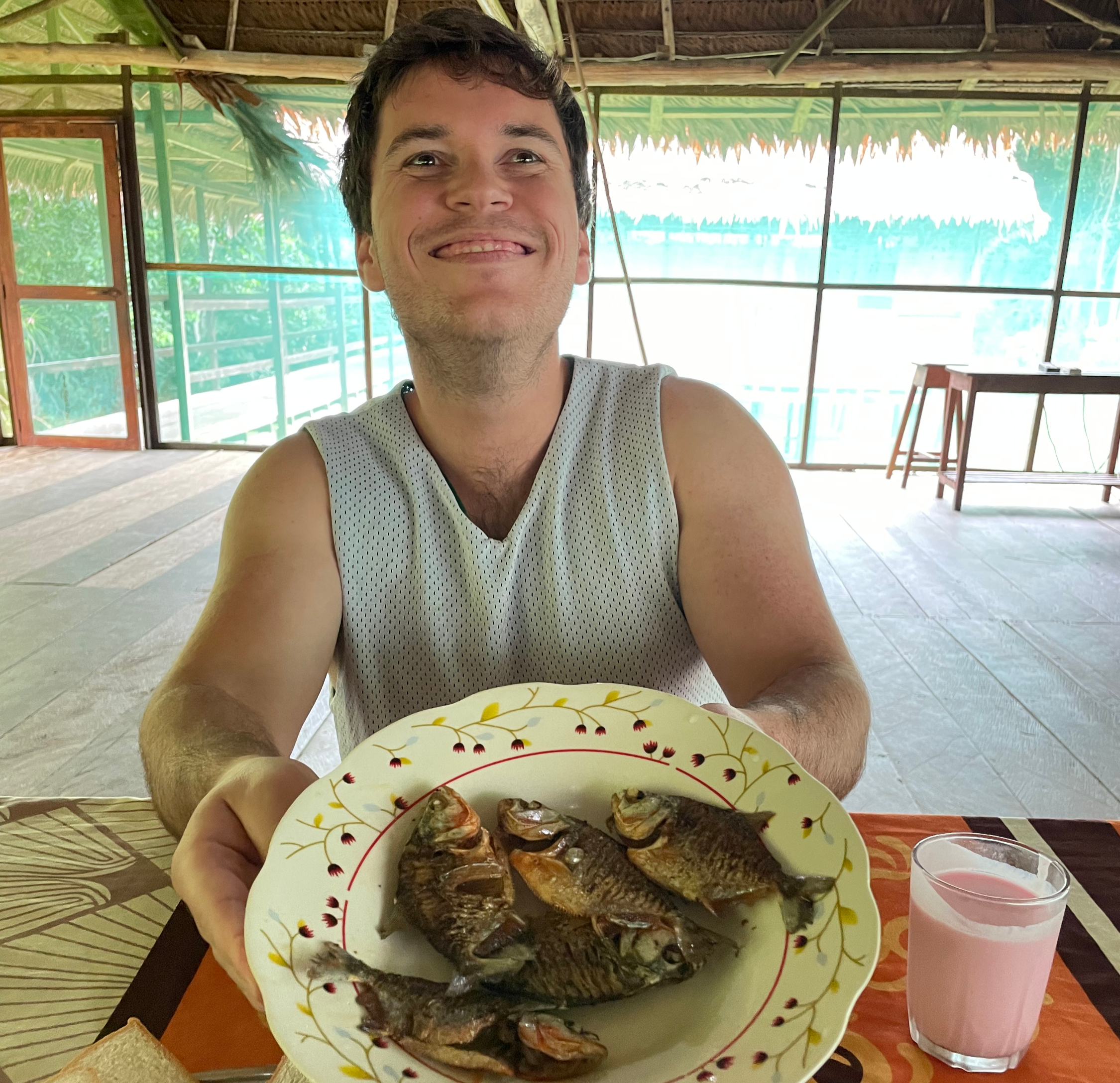 Guest holding a plate of fresh-cooked Amazon fish at the lodge near Iquitos